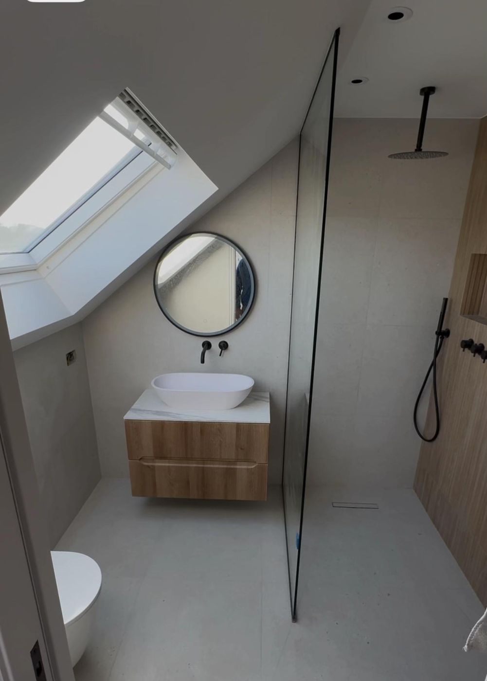Loft shower room with round mirror and walk-in screen